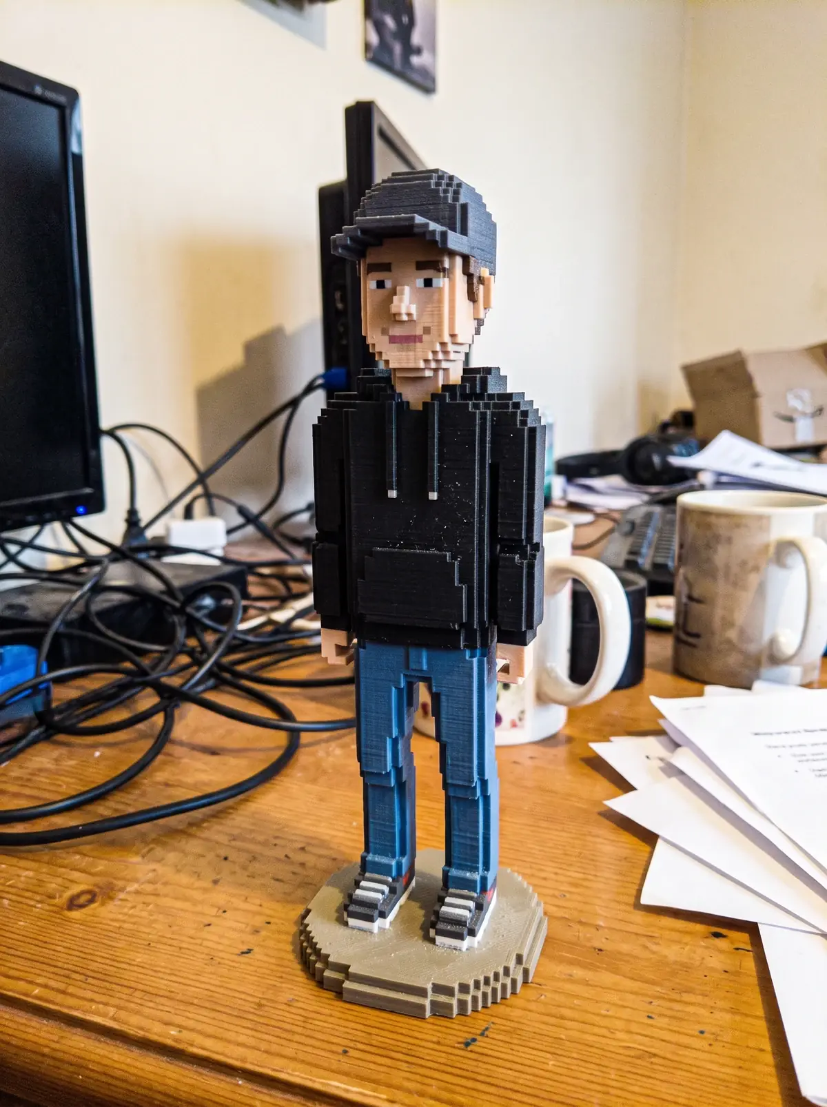 The figurine printed from it: in the living room, cap and black hoodie.